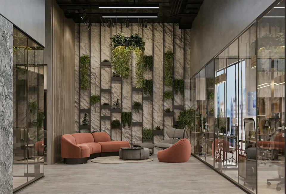 Office lounge with coral curved sofas before a planted shelving wall, flanked by glass-walled offices.