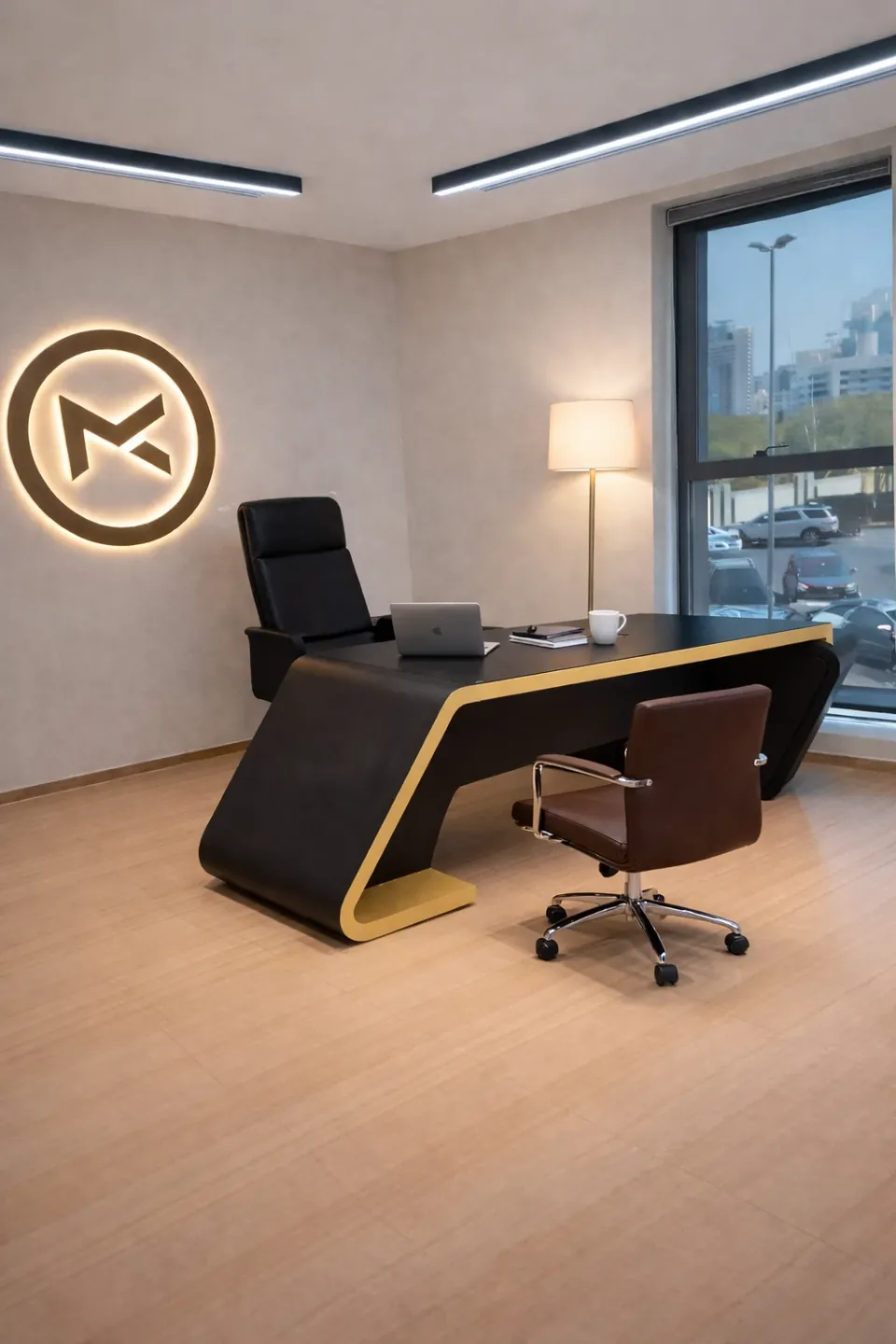 MK Pay, Al Rigga: office with a black and gold curved desk, backlit circular logo, floor lamp and street view.
