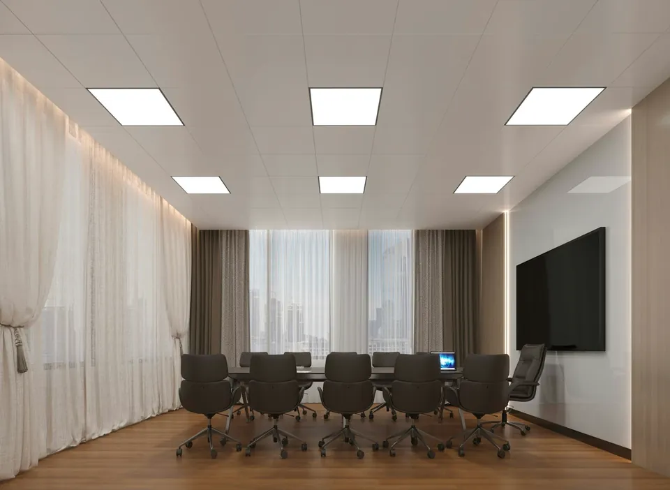 Meeting room with a long table, black office chairs, a wall-mounted screen and sheer curtains over tall windows.